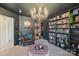Stylish library with chandelier, custom bookshelves, leather chair, and chic ottoman seating area at 5037 Nighthawk Dr, Fort Mill, SC 29707