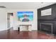 Open-concept living room with dark hardwood floors, a fireplace, and a large TV at 5037 Nighthawk Dr, Fort Mill, SC 29707