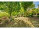 Spacious backyard featuring mature trees, lush greenery, and a patio perfect for outdoor gatherings and relaxation at 5050 Kinross Ln, Indian Land, SC 29707