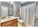 Cozy bathroom with single sink vanity, decorative art, and shower with patterned curtain at 5050 Kinross Ln, Indian Land, SC 29707