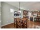 View of dining area with modern chandelier, wood table and view of the open concept kitchen at 5050 Kinross Ln, Indian Land, SC 29707