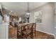 Dining area with modern chandelier, dark wood table and view of open concept kitchen and living room at 5050 Kinross Ln, Indian Land, SC 29707