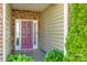 Inviting front porch with a brick facade, colorful door, and lush greenery at 5050 Kinross Ln, Indian Land, SC 29707