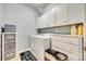 Well-lit laundry room featuring washer, dryer, storage cabinets, and decorative laundry accessories at 5050 Kinross Ln, Indian Land, SC 29707