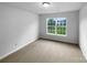 A bright, carpeted bedroom featuring a large window offering an exterior view at 508 Danfield Dr, Clover, SC 29710