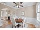 Cozy dining area featuring a round wooden table, four chairs, wainscoting, and a ceiling fan at 627 N Flint St, Lincolnton, NC 28092