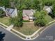 Aerial shot of a charming brick home nestled among lush trees in a friendly neighborhood at 6904 Mordred Ln, Charlotte, NC 28277