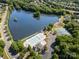 A picturesque aerial shot featuring a lake, community pool, tennis courts, and lush green surroundings at 6904 Mordred Ln, Charlotte, NC 28277