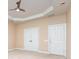 Bedroom featuring a tray ceiling, neutral carpet, and two closets at 6904 Mordred Ln, Charlotte, NC 28277