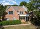 Charming brick home featuring light blue shutters, blooming greenery and a well-manicured lawn at 6904 Mordred Ln, Charlotte, NC 28277