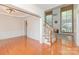 Bright living room featuring hardwood floors, high ceilings, and a staircase with wood railing at 6904 Mordred Ln, Charlotte, NC 28277