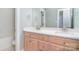 Bathroom featuring a dual sink vanity with wooden cabinets and a large mirror at 6927 Ellington Farm Ln, Mint Hill, NC 28227