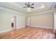 Open bedroom with hardwood floors, tray ceilings, and neutral paint at 6927 Ellington Farm Ln, Mint Hill, NC 28227