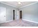 Light-filled bedroom with multiple doorways and soft carpeting, offering versatility at 6927 Ellington Farm Ln, Mint Hill, NC 28227