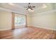 Spacious bedroom featuring hardwood floors, tray ceilings, and a large window at 6927 Ellington Farm Ln, Mint Hill, NC 28227