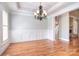 Dining room with hardwood floors, chandelier, wainscoting, and views into other living areas at 6927 Ellington Farm Ln, Mint Hill, NC 28227