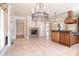 Well-lit kitchen featuring an island, stainless steel appliances, tile flooring, and a stone fireplace at 6927 Ellington Farm Ln, Mint Hill, NC 28227