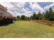 Large backyard featuring a lush lawn, a wooden fence, and mature trees at 7397 Mill Ruins Sw Ave, Concord, NC 28025