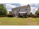 Spacious backyard featuring a lush lawn, a wooden fence, mature shrubs, and a covered outdoor kitchen area at 7397 Mill Ruins Sw Ave, Concord, NC 28025