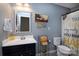 Neutral bathroom featuring a single sink vanity, decorative mirror, and sunflower themed shower curtain at 7397 Mill Ruins Sw Ave, Concord, NC 28025
