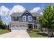Charming two-story home with a manicured lawn, two car garage, and a mix of stone and blue toned siding at 7397 Mill Ruins Sw Ave, Concord, NC 28025