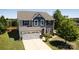 Two-story home featuring a stone and vinyl facade, well-maintained landscaping, and an attached two-car garage at 7397 Mill Ruins Sw Ave, Concord, NC 28025