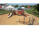 Community playground featuring slides and climbing equipment with a pool and seating areas in the background at 7397 Mill Ruins Sw Ave, Concord, NC 28025