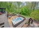 Backyard featuring a hot tub, outdoor kitchen, and stone patio seating area at 78 N Scalybark Trl, Concord, NC 28027