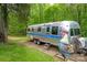 Airstream trailer parked in a wooded backyard with a decorative rooster statue at 78 N Scalybark Trl, Concord, NC 28027