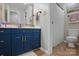 Bathroom with blue vanity and shower/tub with white curtain at 902 Hoke Trl, Cramerton, NC 28032