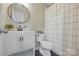 Modern bathroom with round mirror, white vanity, and shower with decorative curtain at 902 Hoke Trl, Cramerton, NC 28032