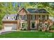 Charming two-story brick home with black shutters, manicured lawn, and attached two-car garage at 902 Hoke Trl, Cramerton, NC 28032