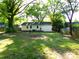 Expansive backyard featuring a lush green lawn and mature trees, providing ample space for outdoor activities and relaxation at 906 N 11Th St, Albemarle, NC 28001