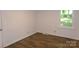 Comfortable bedroom with hardwood floors, a window overlooking the backyard, and freshly painted walls at 906 N 11Th St, Albemarle, NC 28001