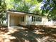 Charming single-story home with a covered carport, lush green trees, and a well-manicured lawn at 906 N 11Th St, Albemarle, NC 28001