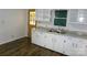 Well-lit kitchen with white cabinetry, granite countertops, and hardwood floors, perfect for cooking and entertaining at 906 N 11Th St, Albemarle, NC 28001
