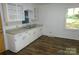 Functional kitchen featuring white cabinets, a double sink, and a bright window overlooking the backyard at 906 N 11Th St, Albemarle, NC 28001