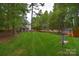 Expansive backyard featuring a large lawn, mature trees, storage shed, and disc golf target at 9106 Dogwood Ridge Dr, Charlotte, NC 28227
