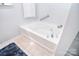 Close-up of a clean, white bathtub with chrome fixtures, a tile surround, and a textured bath mat at 9106 Dogwood Ridge Dr, Charlotte, NC 28227