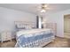Cozy bedroom with neutral walls, carpet flooring, ceiling fan, and a bed with blue bedding at 9106 Dogwood Ridge Dr, Charlotte, NC 28227