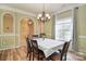 Dining room with elegant chandelier, wainscoting, and window views at 9106 Dogwood Ridge Dr, Charlotte, NC 28227