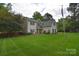 A well-maintained home features a lush green lawn, mature trees, and classic architectural details at 9106 Dogwood Ridge Dr, Charlotte, NC 28227