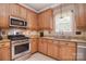 Well-lit kitchen featuring granite countertops, wooden cabinets, and stainless steel appliances at 9106 Dogwood Ridge Dr, Charlotte, NC 28227