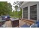Comfortable patio with brick pavers, outdoor seating, a fire pit, and access to a screened porch at 9106 Dogwood Ridge Dr, Charlotte, NC 28227