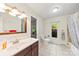 Bright bathroom featuring tile floors, a vanity with a wooden mirror, and a shower-tub combo at 1012 Woodlark Ct, Gastonia, NC 28056