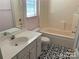 Well-lit bathroom with a tub, single sink vanity, and black and white patterned flooring at 12031 Brownestone View Dr, Charlotte, NC 28269