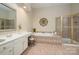 Bathroom with dual sink vanity, soaking tub, and tiled shower with glass door at 12122 Camden Trail Ct, Charlotte, NC 28277