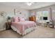 Comfortable bedroom with pink bedding, a ceiling fan, natural light, and a charming workspace at 12122 Camden Trail Ct, Charlotte, NC 28277