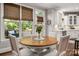 Dining area with wood table and seating situated near large sunlit windows at 12122 Camden Trail Ct, Charlotte, NC 28277