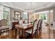 Formal dining room with hardwood floors, elegant chandelier, and large windows at 12122 Camden Trail Ct, Charlotte, NC 28277